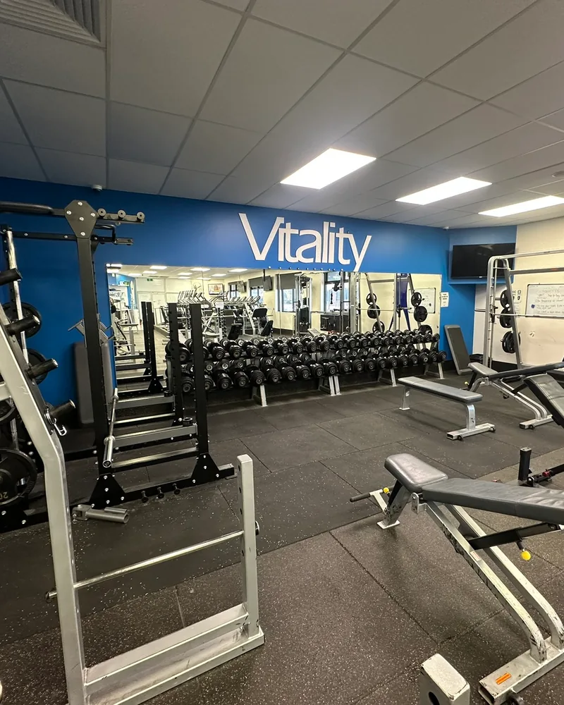 Dumbbell racks, benches and squat stands in the free weights room at Berri, under the Vitality wall